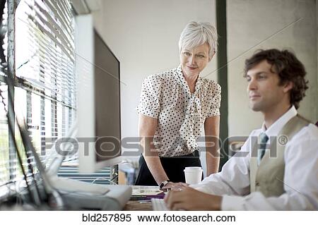 Stock Photography - Business people using computer in office. Fotosearch