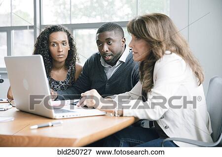 Business people using laptop in meeting View Large Photo Image Stock Photo - Business people using laptop in meeting. Fotosearch