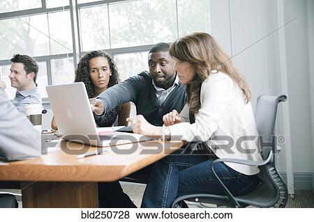 Business people using laptop in meeting View Large Photo Image Stock Photo - Business people using laptop in meeting. Fotosearch