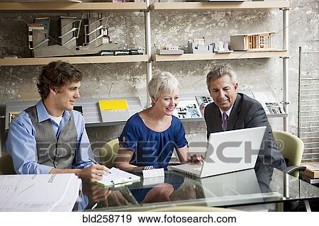 Stock Photo - Business people using laptop in office. Fotosearch