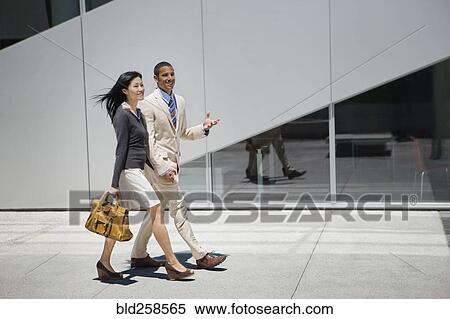 Stock Photography - Business people walking and talking outdoors. Fotosearch