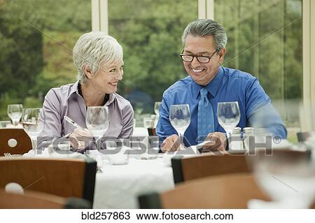 Business people working at table in restaurant View Large Photo Image Stock Image - Business people working at table in restaurant. Fotosearch