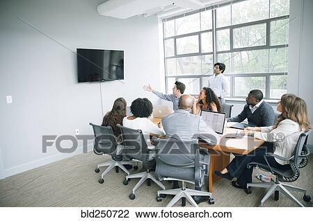 Businessman talking near visual screen in meeting View Large Photo Image Stock Image - Businessman talking near visual screen in meeting. Fotosearch