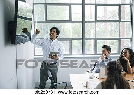 Businessman talking near visual screen in meeting View Large Photo Image Stock Image - Businessman talking near visual screen in meeting. Fotosearch