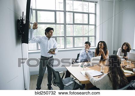 Businessman talking near visual screen in meeting View Large Photo Image Stock Image - Businessman talking near visual screen in meeting. Fotosearch