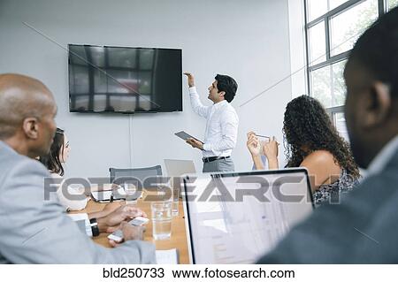 Businessman talking near visual screen in meeting View Large Photo Image Stock Image - Businessman talking near visual screen in meeting. Fotosearch
