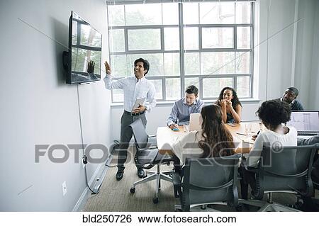 Businessman talking near visual screen in meeting View Large Photo Image Stock Photograph - Businessman talking near visual screen in meeting. Fotosearch