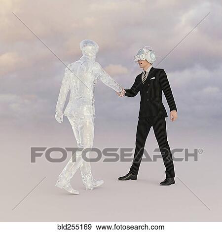 Stock Photo - Businessman wearing virtual reality goggles shaking hands with transparent businessman. Fotosearch