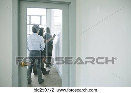 Businessman writing on whiteboard in meeting behind window View Large Photo Image Stock Image - Businessman writing on whiteboard in meeting behind window. Fotosearch