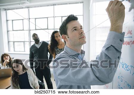 Businessman writing on whiteboard in meeting View Large Photo Image Stock Photography - Businessman writing on whiteboard in meeting. Fotosearch