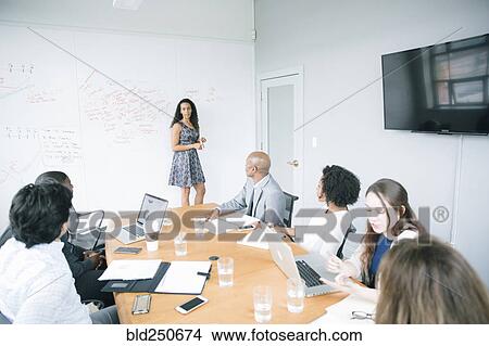 Picture - Businesswoman talking at whiteboard in meeting. Fotosearch