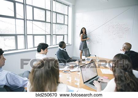 Businesswoman talking at whiteboard in meeting View Large Photo Image Stock Image - Businesswoman talking at whiteboard in meeting. Fotosearch