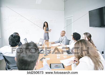 Businesswoman talking at whiteboard in meeting View Large Photo Image Stock Image - Businesswoman talking at whiteboard in meeting. Fotosearch