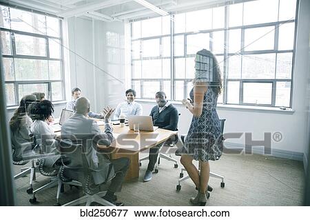 Businesswoman talking behind window in meeting View Large Photo Image Stock Photo - Businesswoman talking behind window in meeting. Fotosearch