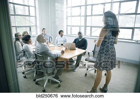 Businesswoman talking behind window in meeting View Large Photo Image Stock Photograph - Businesswoman talking behind window in meeting. Fotosearch