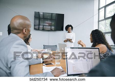 Businesswoman talking near visual screen in meeting View Large Photo Image Picture - Businesswoman talking near visual screen in meeting. Fotosearch