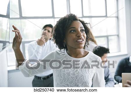 Businesswoman talking near visual screen in meeting View Large Photo Image Stock Image - Businesswoman talking near visual screen in meeting. Fotosearch