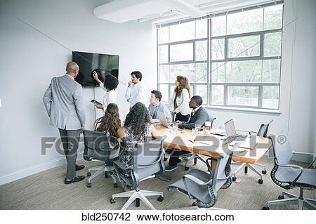 Businesswoman talking near visual screen in meeting View Large Photo Image Stock Image - Businesswoman talking near visual screen in meeting. Fotosearch