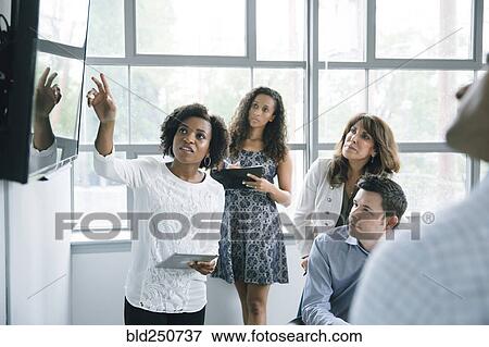 Businesswoman talking near visual screen in meeting View Large Photo Image Stock Photo - Businesswoman talking near visual screen in meeting. Fotosearch