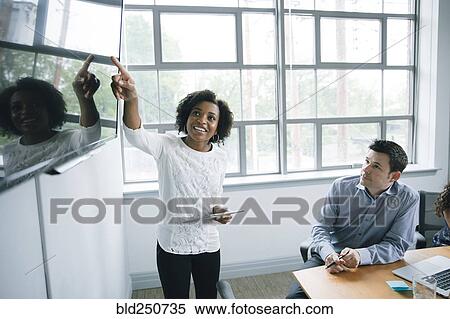 Businesswoman talking near visual screen in meeting View Large Photo Image Stock Photography - Businesswoman talking near visual screen in meeting. Fotosearch
