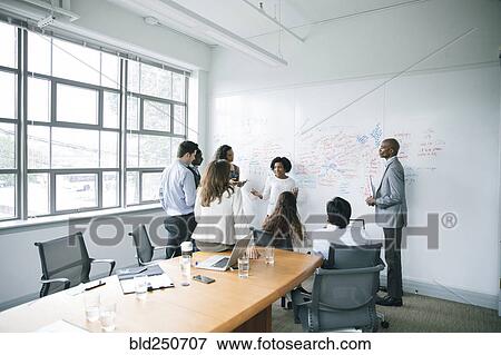 Stock Photo - Businesswoman talking near whiteboard in meeting. Fotosearch