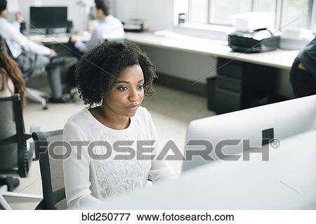 Stock Photo - Businesswoman using computer in office. Fotosearch