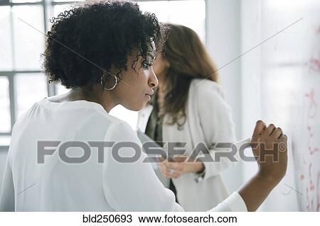 Businesswoman writing on whiteboard in meeting View Large Photo Image Stock Image - Businesswoman writing on whiteboard in meeting. Fotosearch