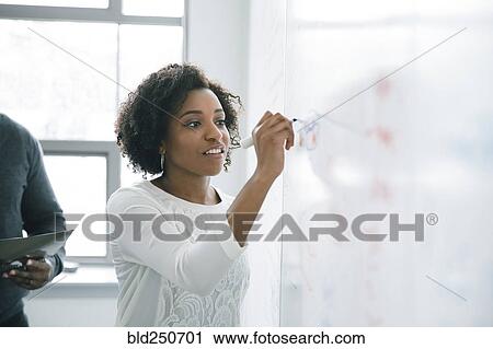 Businesswoman writing on whiteboard in meeting View Large Photo Image Stock Image - Businesswoman writing on whiteboard in meeting. Fotosearch