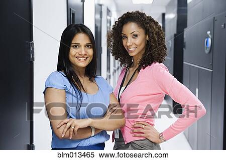 Stock Photography - Businesswomen standing in server room. Fotosearch