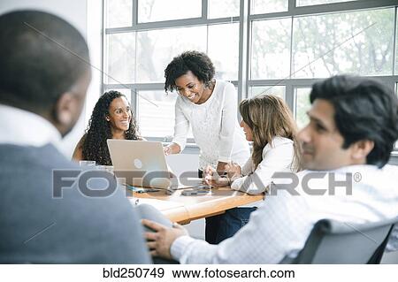 Stock Photo - Businesswomen using laptop in meeting. Fotosearch