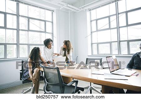Stock Photo - Businesswomen using laptop in meeting. Fotosearch
