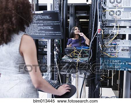 Stock Photography - Businesswomen working in server room. Fotosearch