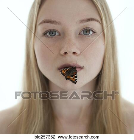 Stock Image - Butterfly on lips of Caucasian teenage girl. Fotosearch