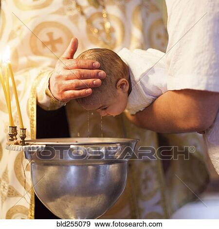 Stock Photo - Caucasian baby girl being baptized. Fotosearch
