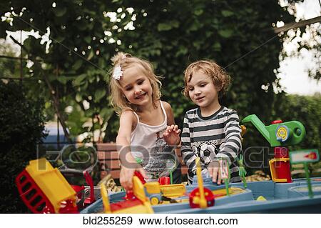 Caucasian boy and girl playing with toys outdoors View Large Photo Image Stock Photo - Caucasian boy and girl playing with toys outdoors. Fotosearch