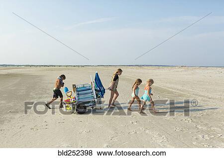 Caucasian boy and girls pulling cart on beach View Large Photo Image Stock Photo - Caucasian boy and girls pulling cart on beach. Fotosearch