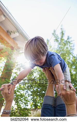 Caucasian boy balancing on feet of mother View Large Photo Image Picture - Caucasian boy balancing on feet of mother. Fotosearch