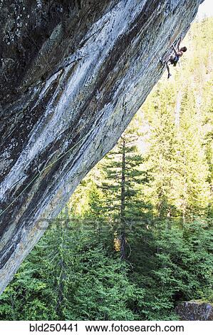 Stock Image - Caucasian boy climbing rock. Fotosearch