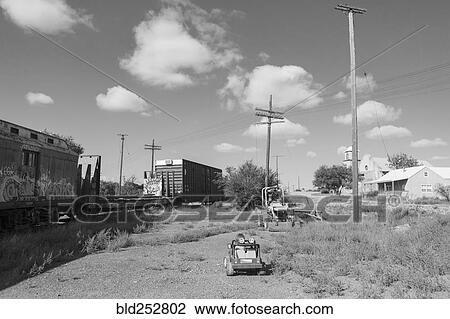 Stock Image - Caucasian boy driving toy car near train. Fotosearch