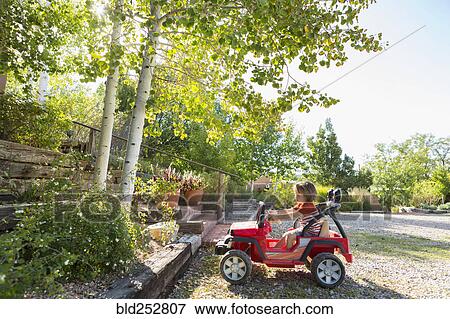 Stock Photo - Caucasian boy driving toy car. Fotosearch