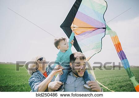 Caucasian boy flying kite with father and grandmother View Large Photo Image Stock Photograph - Caucasian boy flying kite with father and grandmother. Fotosearch