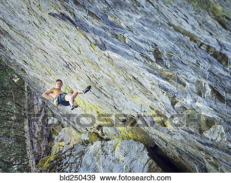 Caucasian boy hanging from rope on rock View Large Photo Image Stock Photo - Caucasian boy hanging from rope on rock. Fotosearch