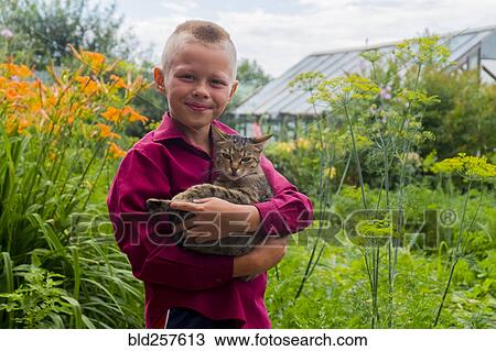 Caucasian boy holding cat on farm View Large Photo Image Stock Image - Caucasian boy holding cat on farm. Fotosearch