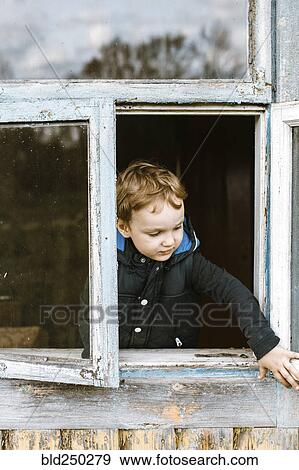 Stock Photo - Caucasian boy opening window. Fotosearch