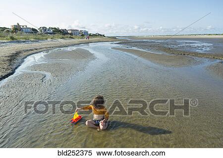 Caucasian boy playing with sailboat in waves on beach View Large Photo Image Stock Photography - Caucasian boy playing with sailboat in waves on beach. Fotosearch