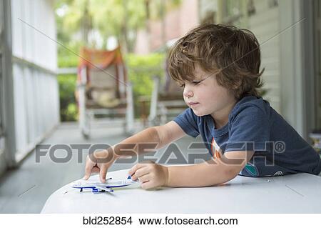 Picture - Caucasian boy playing with toy airplane. Fotosearch