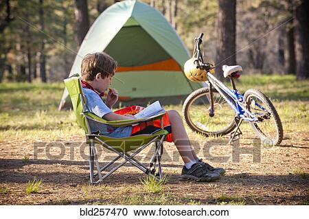 Caucasian boy reading book at campground View Large Photo Image Stock Image - Caucasian boy reading book at campground. Fotosearch