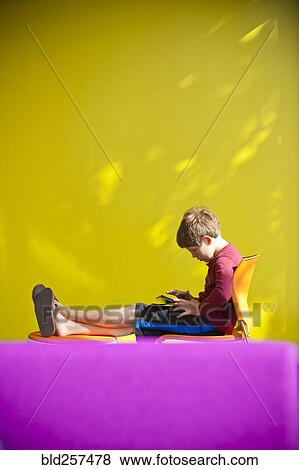 Caucasian boy relaxing and reading digital tablet View Large Photo Image Stock Photo - Caucasian boy relaxing and reading digital tablet. Fotosearch