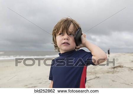 Caucasian boy talking on cell phone on beach View Large Photo Image Stock Image - Caucasian boy talking on cell phone on beach. Fotosearch
