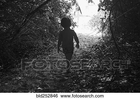 Stock Photograph - Caucasian boy walking on sandy path. Fotosearch